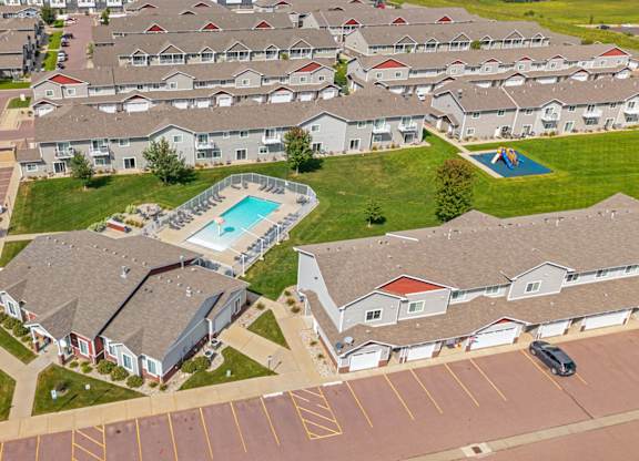 A swimming pool is surrounded by houses in a residential area.
