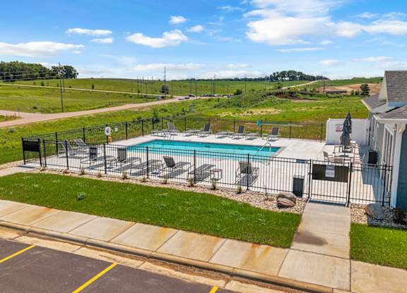 A pool surrounded by a fence and a house.