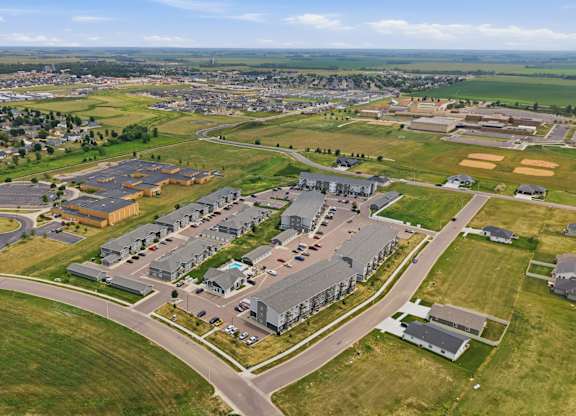A large, open grassy area with a few buildings in the distance.