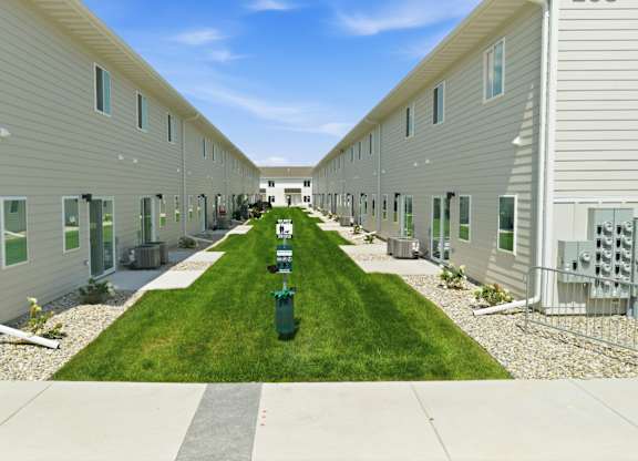 A long row of houses with green grass in the middle.