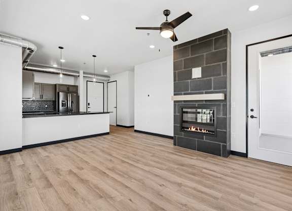 A modern kitchen with a wood floor and a fireplace.