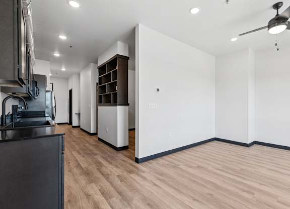 A modern kitchen with wooden floors and white walls.