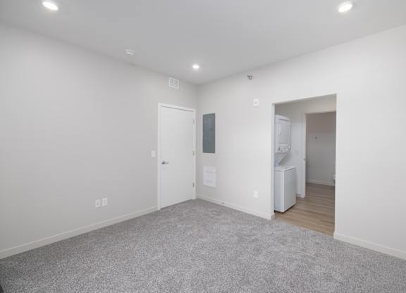 A room with a grey carpet and white walls.