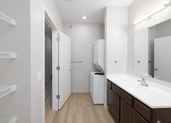 A white bathroom with a white sink and a white cabinet.