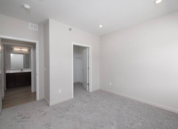 A large empty room with a carpeted floor and white walls.
