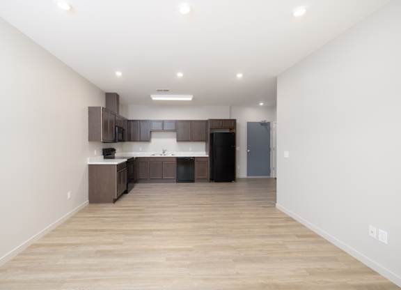 A kitchen with wooden floors and white walls.