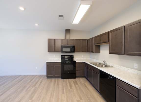 A kitchen with brown cabinets and a black oven.