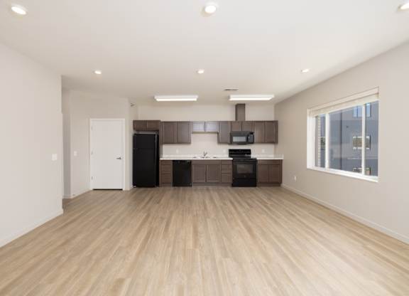 A spacious kitchen with wooden floors and modern appliances.