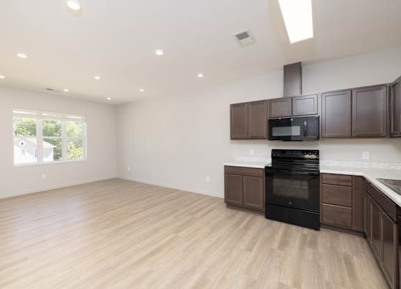 A kitchen with wooden floors and a black oven.