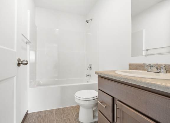 A white toilet sits in a bathroom next to a sink.