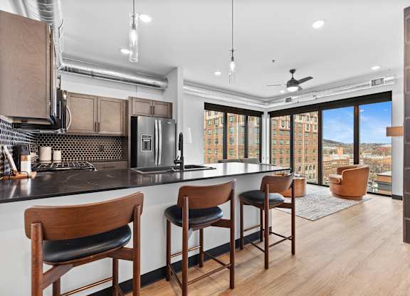 A kitchen with a bar area and a view of the city.