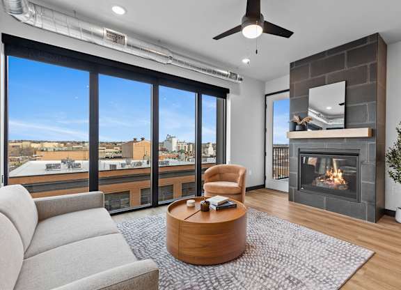 A modern living room with a fireplace and a view of the city.