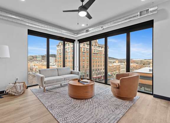 A living room with a large window overlooking a cityscape.