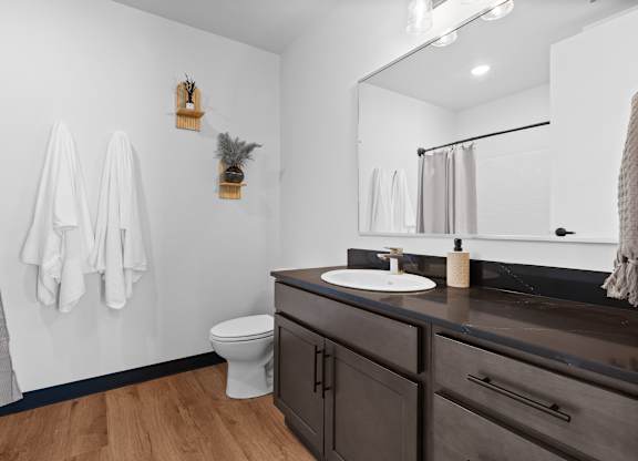 A bathroom with a toilet, sink, and towel rack.