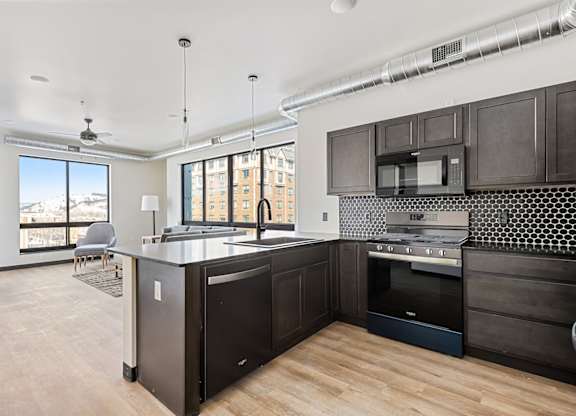 A kitchen with dark wood cabinets and a large island.