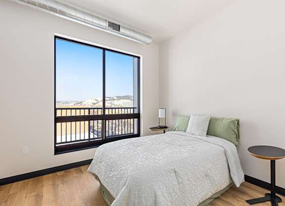 A bedroom with a large bed and a view of the mountains outside.