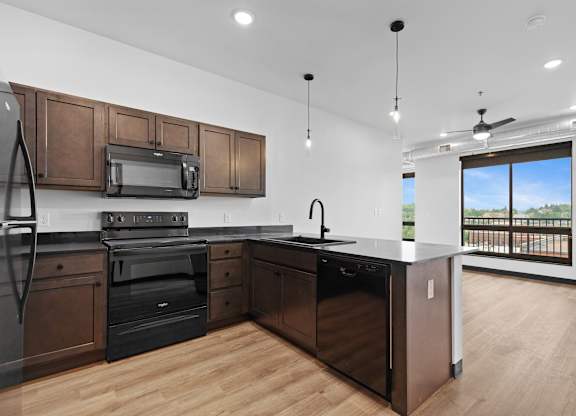 A modern kitchen with dark wood cabinets and stainless steel appliances.