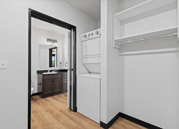 A white kitchen with a refrigerator, oven, and sink.