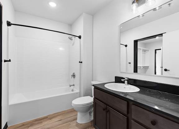 A white toilet sits in a bathroom next to a sink.