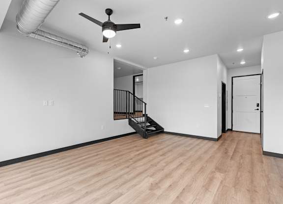 A room with a wooden floor and a ceiling fan.