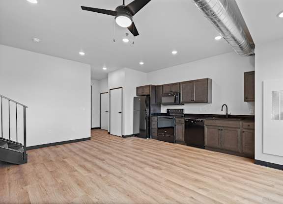 A kitchen with a refrigerator, sink, and cabinets.