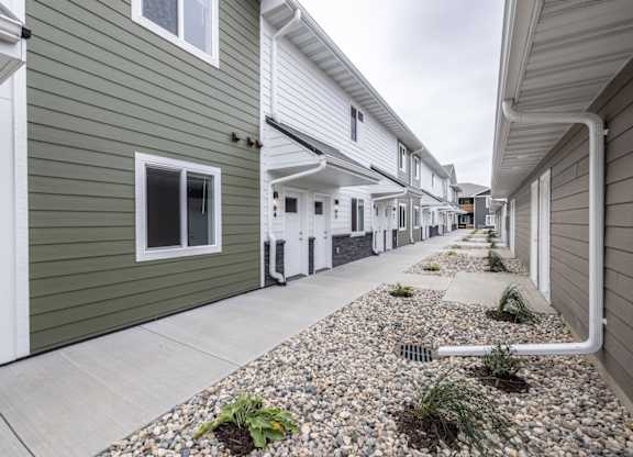 A row of houses with a gravel area in the foreground.
