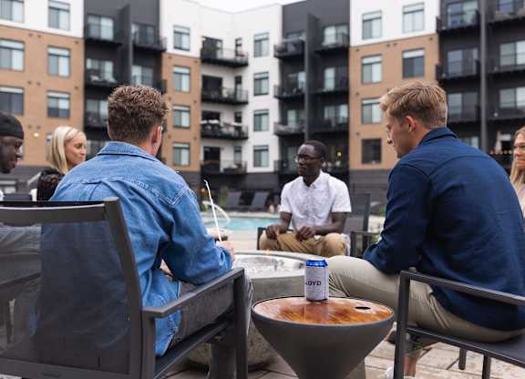 A group of people are sitting around a table on a rooftop.