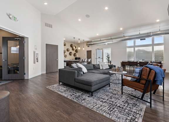 A living room with a grey couch and a wooden chair.