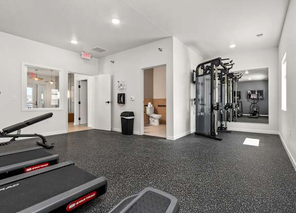A gym with treadmills, weights, and other exercise equipment.
