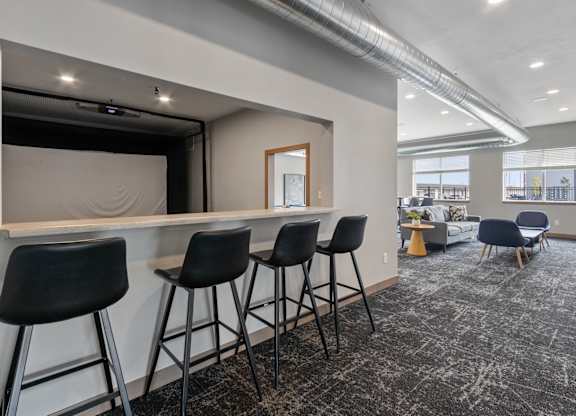 A room with a bar and chairs.