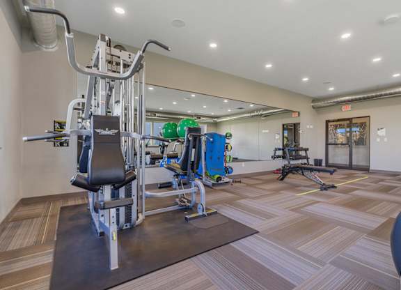 A gym with a variety of equipment including a leg press machine.