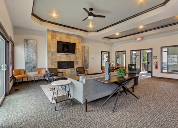 A living room with a stone fireplace and a grey sofa.