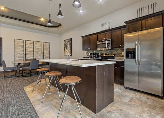 A modern kitchen with a bar area and stools.