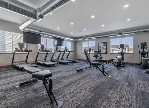A gym with treadmills, exercise bikes, and other equipment.