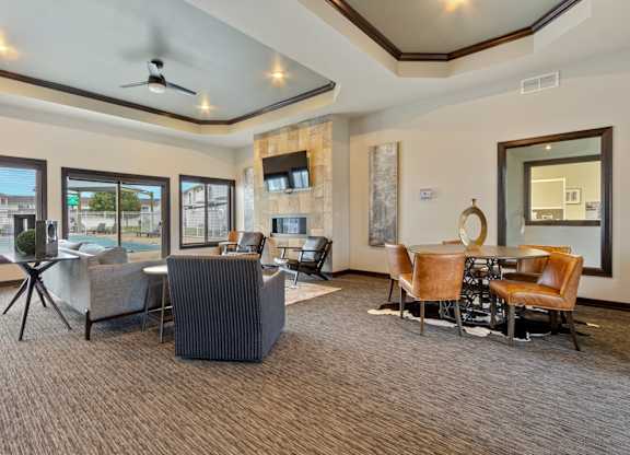 A living room with a grey carpet and brown chairs.