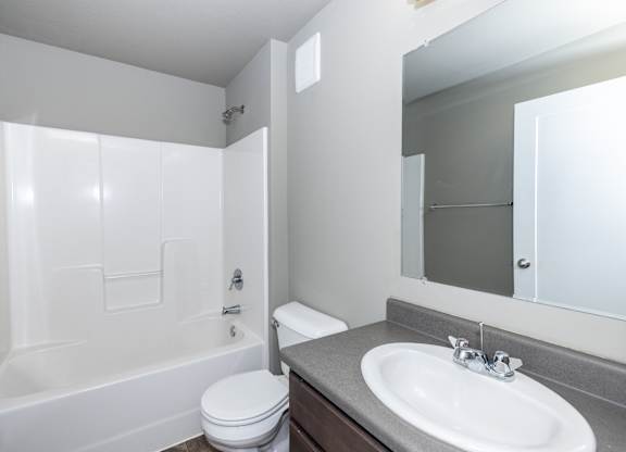 A white bathroom with a toilet, sink, and bathtub.