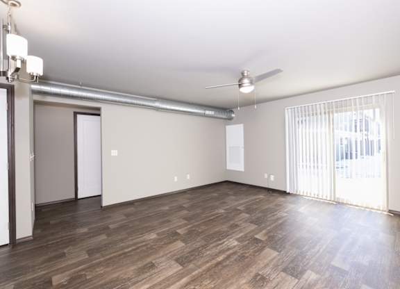 A room with wooden flooring and a ceiling fan.