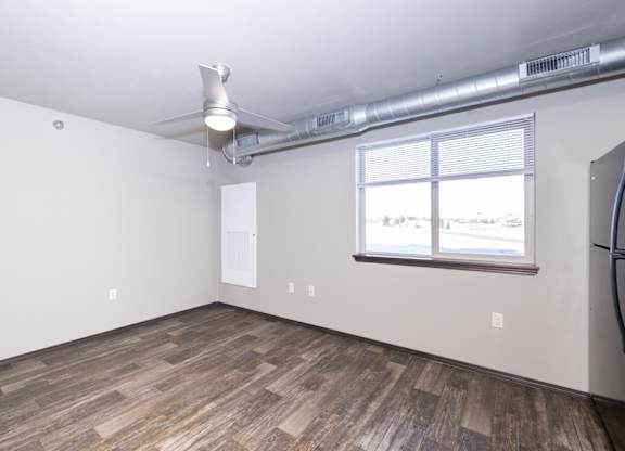 A room with a window and a fan on the ceiling.