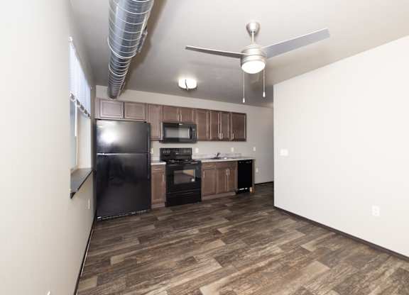 A kitchen with a black fridge, microwave, and stove.