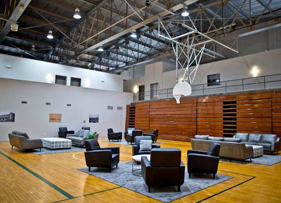 A basketball court with a hoop and a variety of seating.