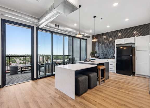 A modern kitchen with a large island and a view of the outside.