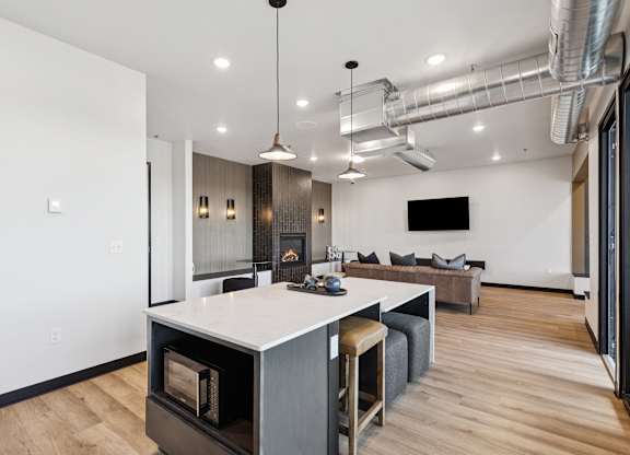 A modern kitchen with a white island and a bar stool.