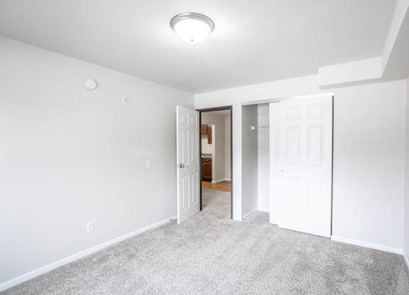 a bedroom with a closet and a door to a bathroom