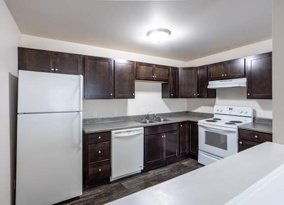 a kitchen with white appliances and dark wood cabinets
