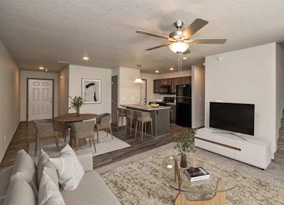 A living room with a couch, a coffee table, a television, and a staircase.