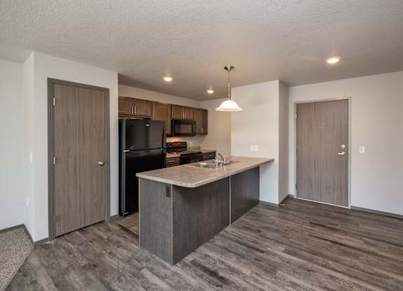 A kitchen with a wooden floor and a counter.