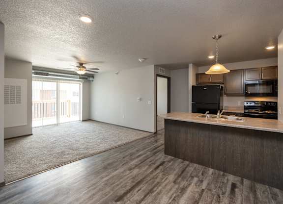 A kitchen with a black fridge and microwave.