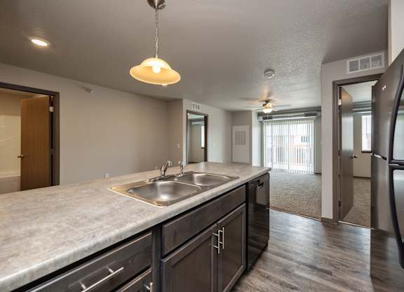 A kitchen with a sink and a refrigerator.