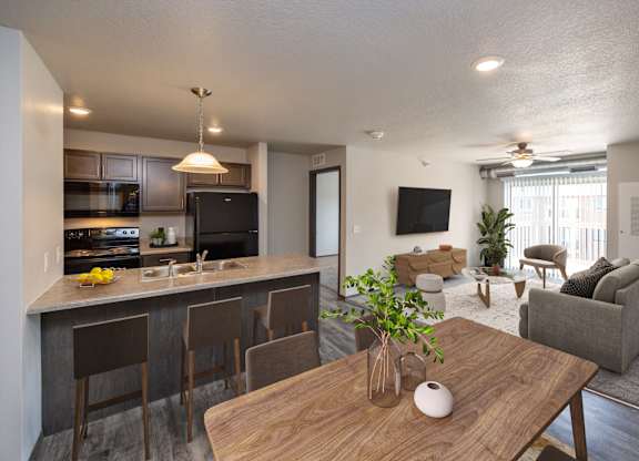 A modern kitchen with a bar and a dining table.