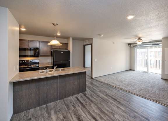 A modern kitchen with a bar area and a large open living space.